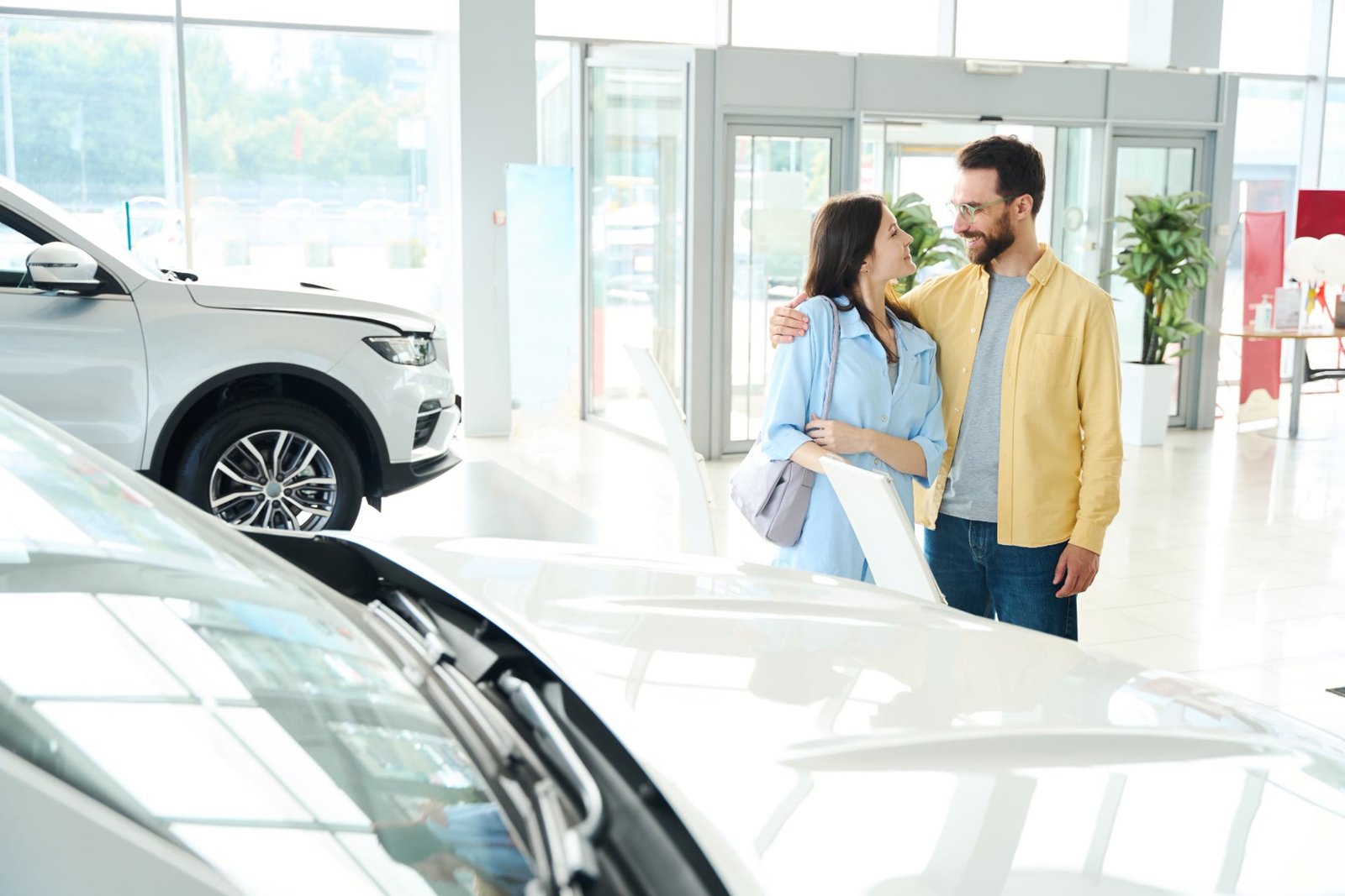 Galeride yeni aracına bakan mutlu çift